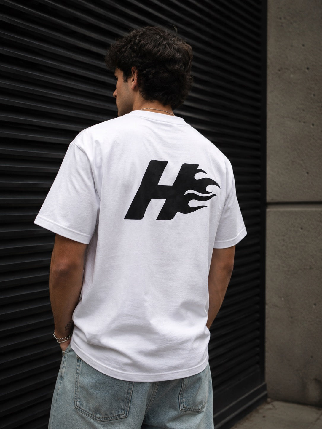 Camiseta oversize HeatCore blanca con logo de la llama en la espalda, vista de modelo