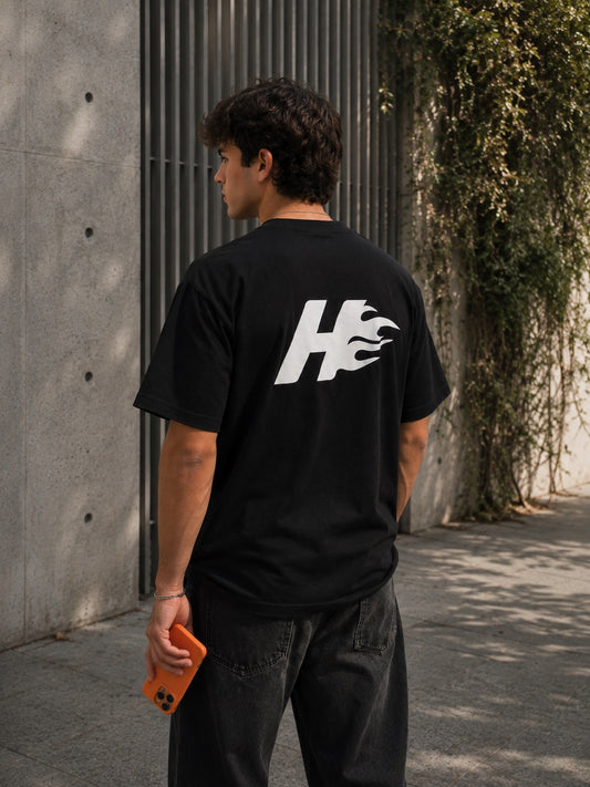 Camiseta oversize HeatCore negra con logo de la llama en la espalda, vista de modelo